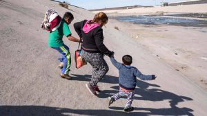 A group of Central American migrants -mostly from Honduras- run along