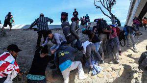Migrantes intentan cruzar muro con EE.UU. y reciben gas lacrimgeno