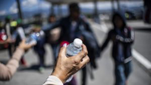 Members of the Mexican Comision for the Human Rights offer water to m