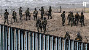 US border patrol agents stand guard as pro-migrants activists demonst