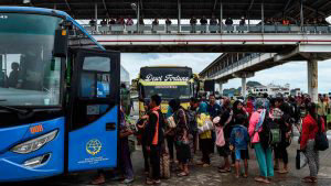 Residents board a bus at the ferry port after being evacuated from Se