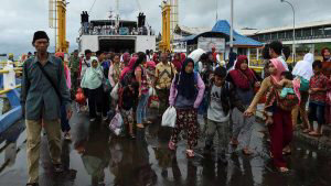 Residents disembark from a ferry at the port after being evacuated fr