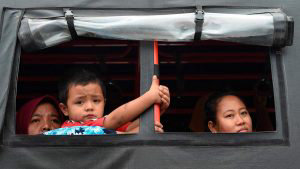 A boy looks out the window after disembarking from a ferry at the por