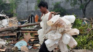 TOPSHOT - A man carries items he salvaged from an area hit by a tsuna