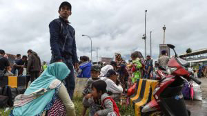 A family eat after disembarking from a ferry at the port after being