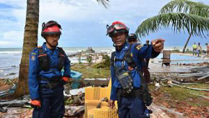 Indonesian firefighters help search and rescue teams look for victims