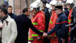 TOPSHOT - French President Emmanuel Macron (L) shakes hands with a fi