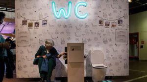 A woman sit on a toilet at the exhibition entitled 
