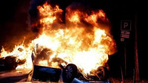 TOPSHOT - A car burns on the sideline of a demonstration by Yellow ve