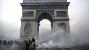 TOPSHOT - Demonstrators clash with riot police at the Arc de Triomphe