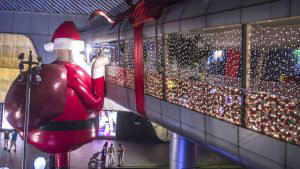 A large inflatable Santa Claus decorates the walkway facade of a mall