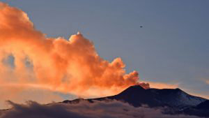 Smoke rises from Mount Etna as seen at sunset from the city of Giarre