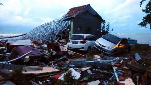Debris from damaged buildings and cars are seen near the beach in Any