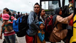 Residents board a bus at the ferry port after being evacuated from Se