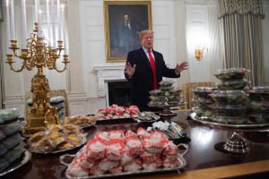 US President Donald Trump speaks alongside fast food he purchased for