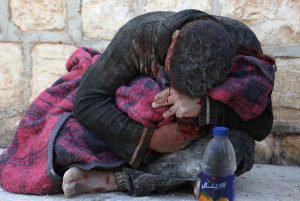 A Syrian man weeps as he cradles the body of his daughter who was kil