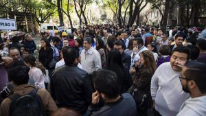 People wait on the streets after an earth tremor in Mexico City on Fe