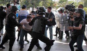 Nicaraguan riot police officers struggle with AFP videographer Luis S