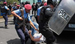 Nicaraguan riot police officers detain a protester before a demonstra