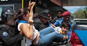 Nicaraguan riot police officers arrest protesters before a demonstrat