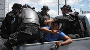 TOPSHOT - Nicaraguan riot police officers leave with two people arres/ La Polica de Nicaragua captur el sbado al menos a 31 personas previo a una manifestacin antigubernamental, incluidos periodistas, lderes opositores, una exguerrillera sandinista y un exministro de Educacin, inform la Unidad Nacional Azul y Blanco.