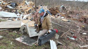 Joey Roush carries items from his mother's home after it was destroye