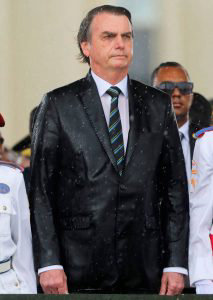 Brazilian President Jair Bolsonaro is drenched with rain as he attend