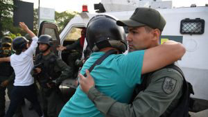 A Venezuelan man hugs a member of the security forces in Caracas on A