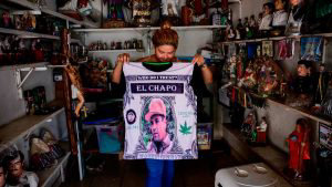 A vendor shows a shirt depicting a portrait of Mexican drug lord Joaq