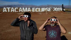 TOPSHOT - Tourists try special glasses to watch an eclipse at the ent
