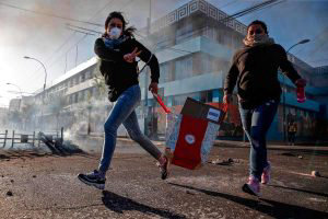TOPSHOT - A looter flashes the V sign as she runs during protests in