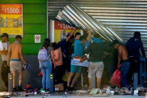 People loot a supermarket in Puente Alto