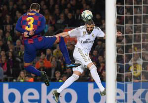 Barcelona's Spanish defender Gerard Pique (L) vies woith Real Madrid'