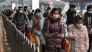 People wearing masks arrive at Hongqioa train station as they head ho