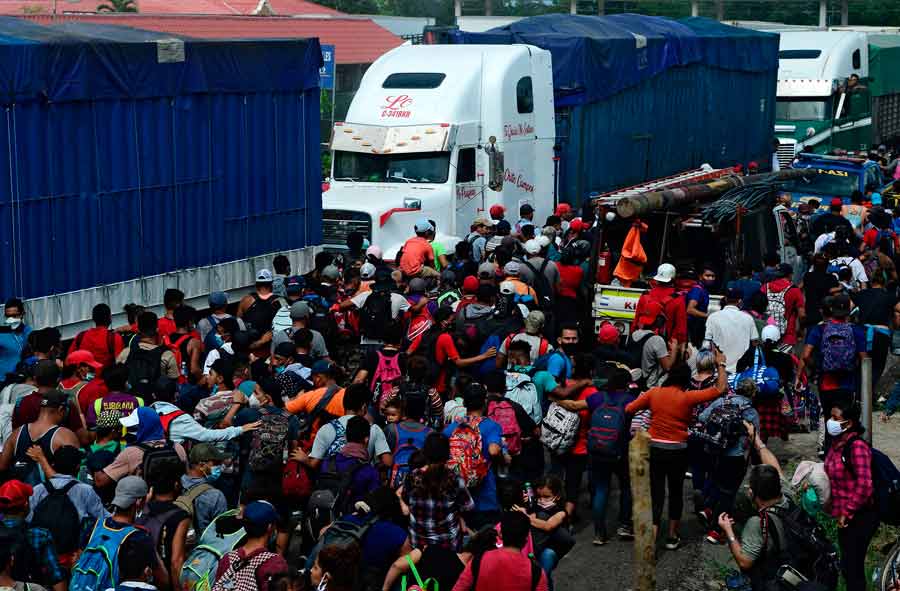 Honduran migrants run after breaking a police fence and entering Guat