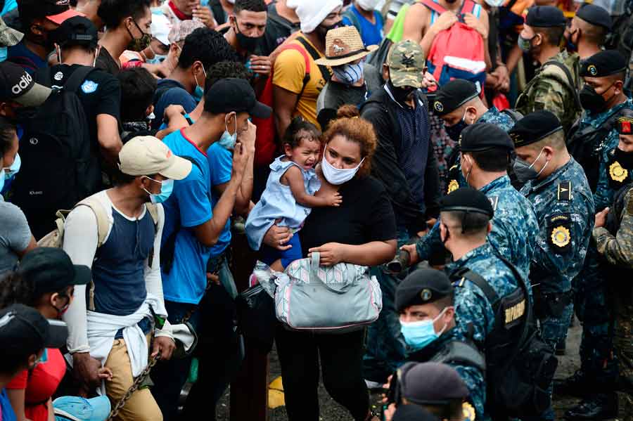 Honduran migrants break the police fence to enter Guatemala on their