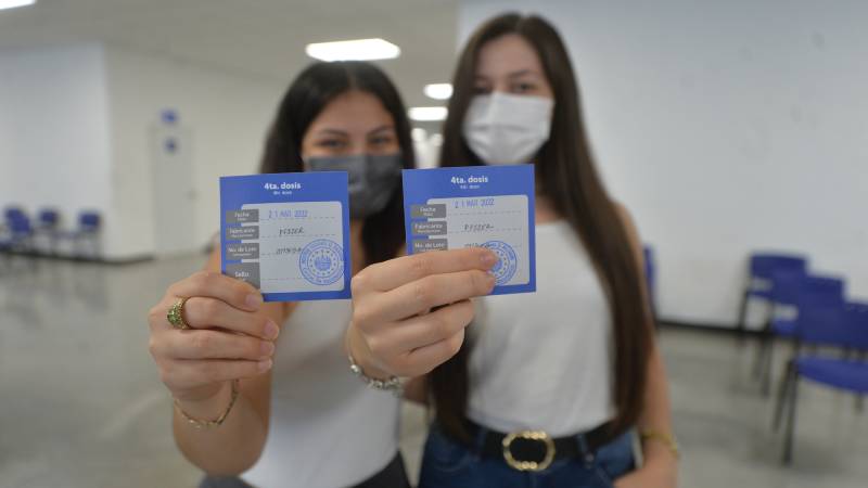 Dos jóvenes muestran sus cartillas con cuatro dosis de vacuna anticovid recibidas, en el Hospital El Salvador. / Foto EDH 