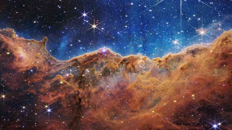 Esta imagen publicada por la NASA el 12 de julio de 2022 desde el Telescopio espacial James Webb (JWST) muestra un paisaje de "montañas" y "valles" salpicado de estrellas brillantes que en realidad es el borde de una región cercana, joven y de formación estelar. llamado NGC 3324 en la Nebulosa Carina. FOTO: Folleto / NASA / AFP