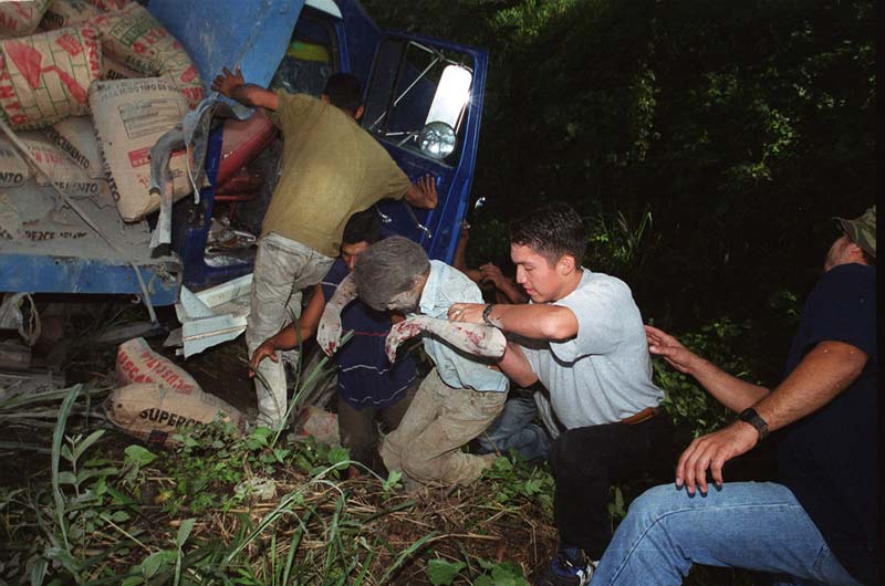 Un hombre en el momento que es rescatado de entre bolsas de cemento que lo sepultaron en un accidente de tránsito en Santa Ana en septiembre de 2000. Foto Antolín Escobar