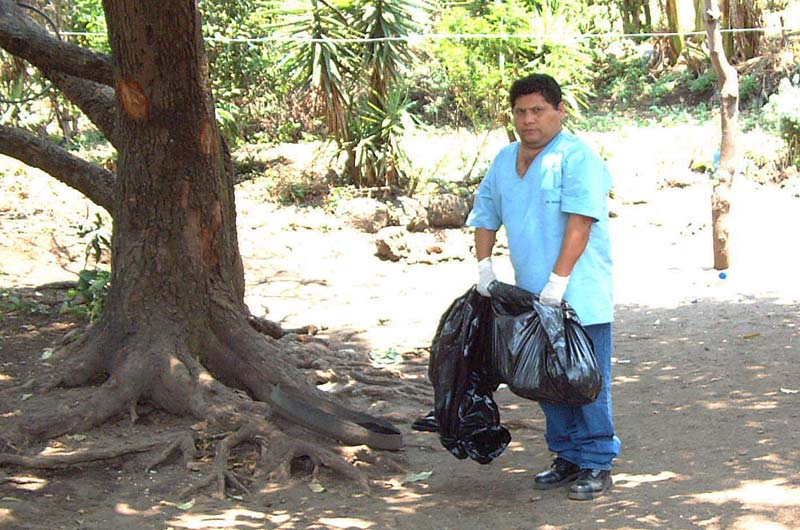 Un empleado de Medicina Legal de Santa Ana carga una bolsa con el cuerpo de una menor de edad que murió a manos de sus propios padres durante un supuesto exorcismo. Los padres pertenecían a una iglesia cristiana fundamentalista. Foto Antolín Escobar