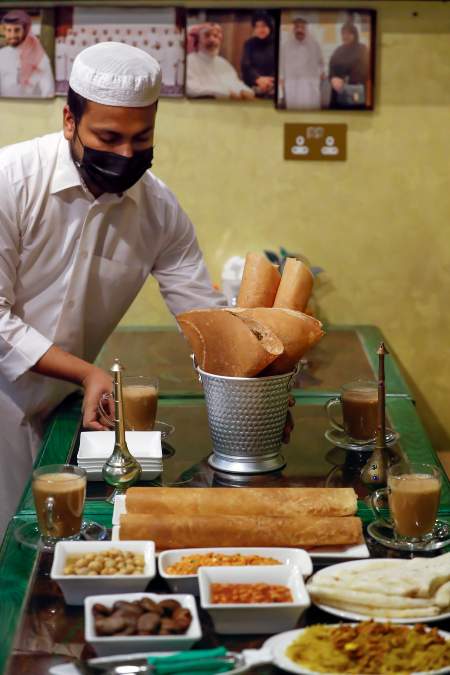 Un camarero prepara una degustación de platos tradicionales en el restaurante Al-Qassabi, propiedad de la cocinera Shams Al-Qassabi, quizás una de las mujeres más empoderadas, respetadas, humildes y ejemplares de todo el emirato que comenzó de cero, rayando limones de su cortijo para hacer condimentos para sus vecinos. Foto/EFE