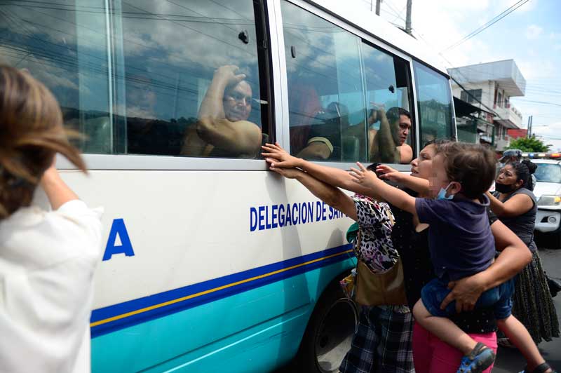 Una madre y su hijo extienden sus brazos hacia un hombre detenido durante el régimen de excepción que estaba siendo trasladado a prisión desde las bartolinas de la PNC de San Salvador. FOTO EDH JESSICA ORELLANA