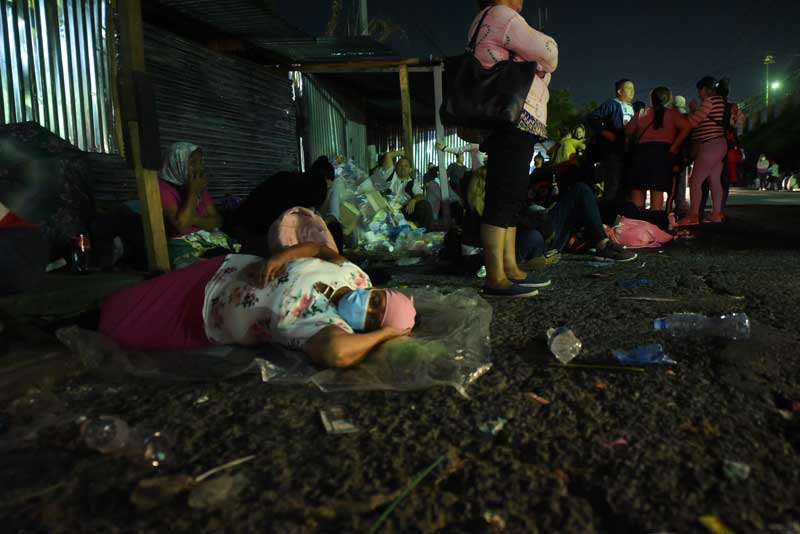 Una mujer duerme sobre un plástico en plena calle frente del penal La Esperanza, conocido como Mariona, el pasado mes de mayo, cuando la falta de información ocasionó que los familiares de detenidos acamparan de noche por decenas, esperando la liberación de reos. FOTO EDH MENLY GONZÁLEZ