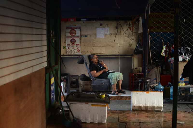 Una mujer habla por teléfono durante el desmantelamiento de su puesto informal en la calle Rubén Darío por el reordenamiento del Centro Histórico de la capital que implicó el desalojo de cientos de comerciantes de las aceras. FOTO EDH FRANCISCO RUBIO