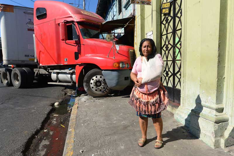 Ángela del Carmen Villalobos, de 61 años, sobrevivió de milagro de ser aplastada por una rastra que se estrelló contra un local donde guarda su venta en la calle Concepción de San Salvador. FOTO EDH JORGE REYES