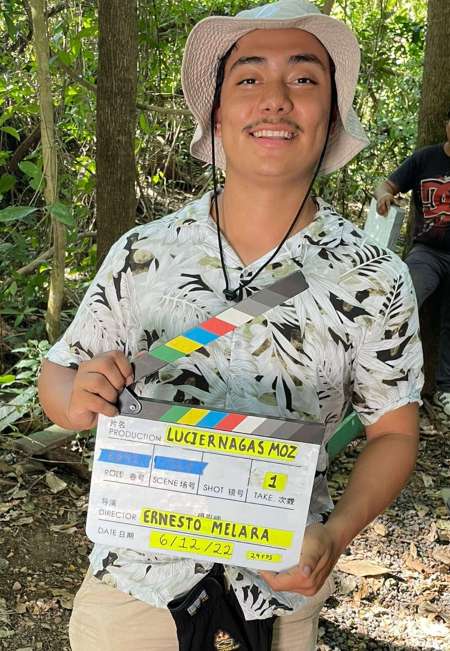 El asistente de cámara Daniel Mejía sostiene una pizarra con el nombre del director de "Luciérnagas en El Mozote", Ernesto Melara, quien también es salvdoreño. Foto: EDH