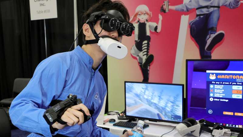 Tomohiko Fukaya demuestra el dispositivo de seguimiento de cuerpo completo de Shiftall, incluido el micrófono Bluetooth mutalk sobre su boca y los controladores FlipVR, para jugar VR en el metaverso. Foto / AFP