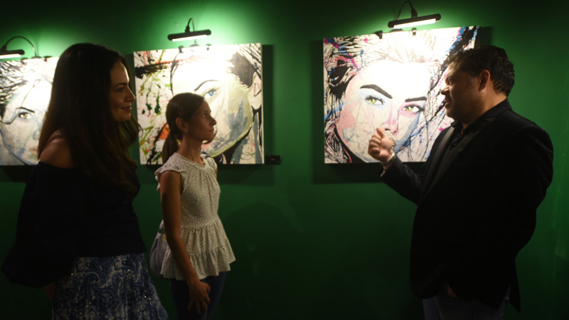 El pintor con dos de las asistentes a la inauguración de la muestra. Foto EDH/ Yessica Hompanera