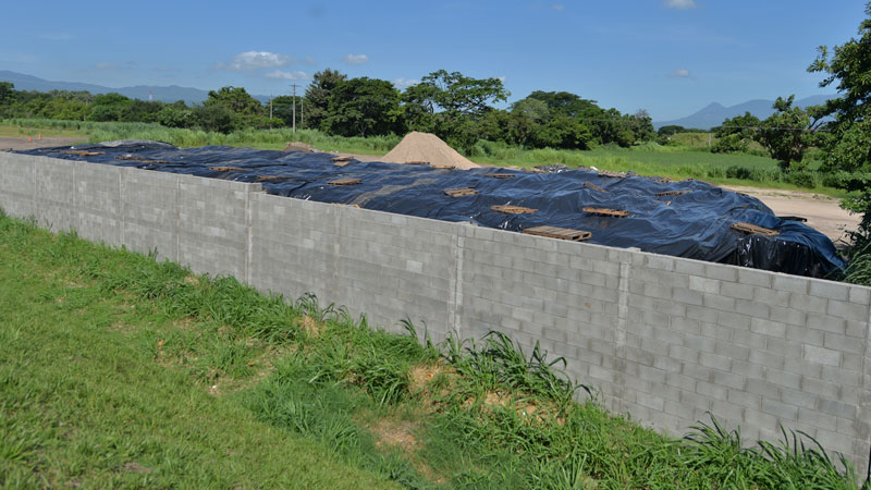 Foto del 19 de julio 2023, un día después de la denuncia hecha por Ganaderos de El Salvador, de la montaña de paquetes agrícolas arruinados. Alguien había mandado a cubrirlos con nuevo plástico para que no se vieran desde la carretera. Foto EDH / Francisco Rubio