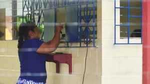 Una mujer entrega dinero efectivo en la ventanilla donde se hacen depósitos a 